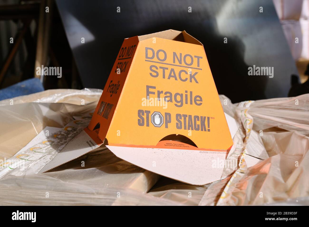 A yellow cardboard Stop Stack anti crush device stating Do Not Stack