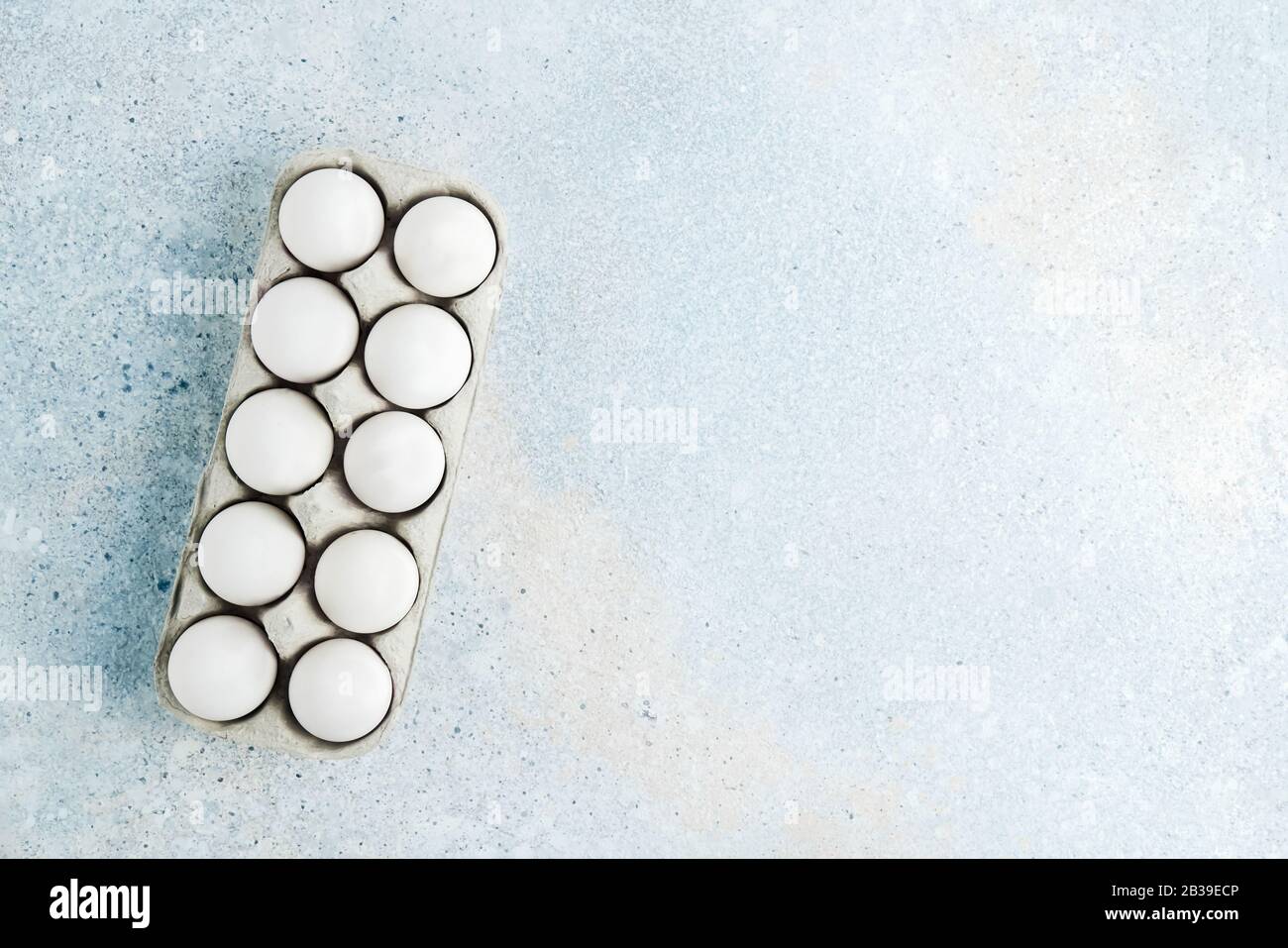 Box with white eggs on blue background. Flatlay, copy space Stock Photo