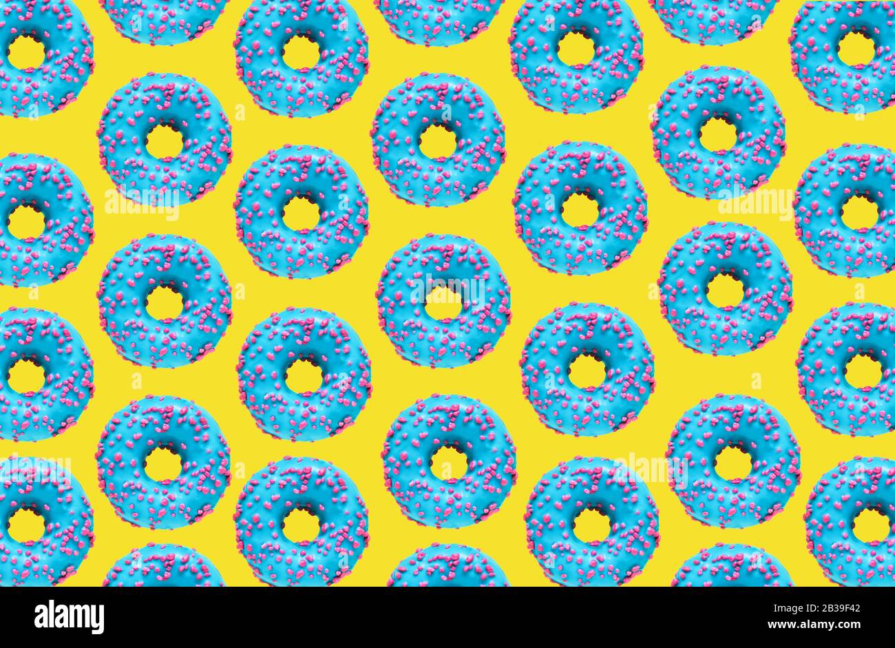 Pattern of a blue donuts on a yellow background. Flat lay Stock Photo