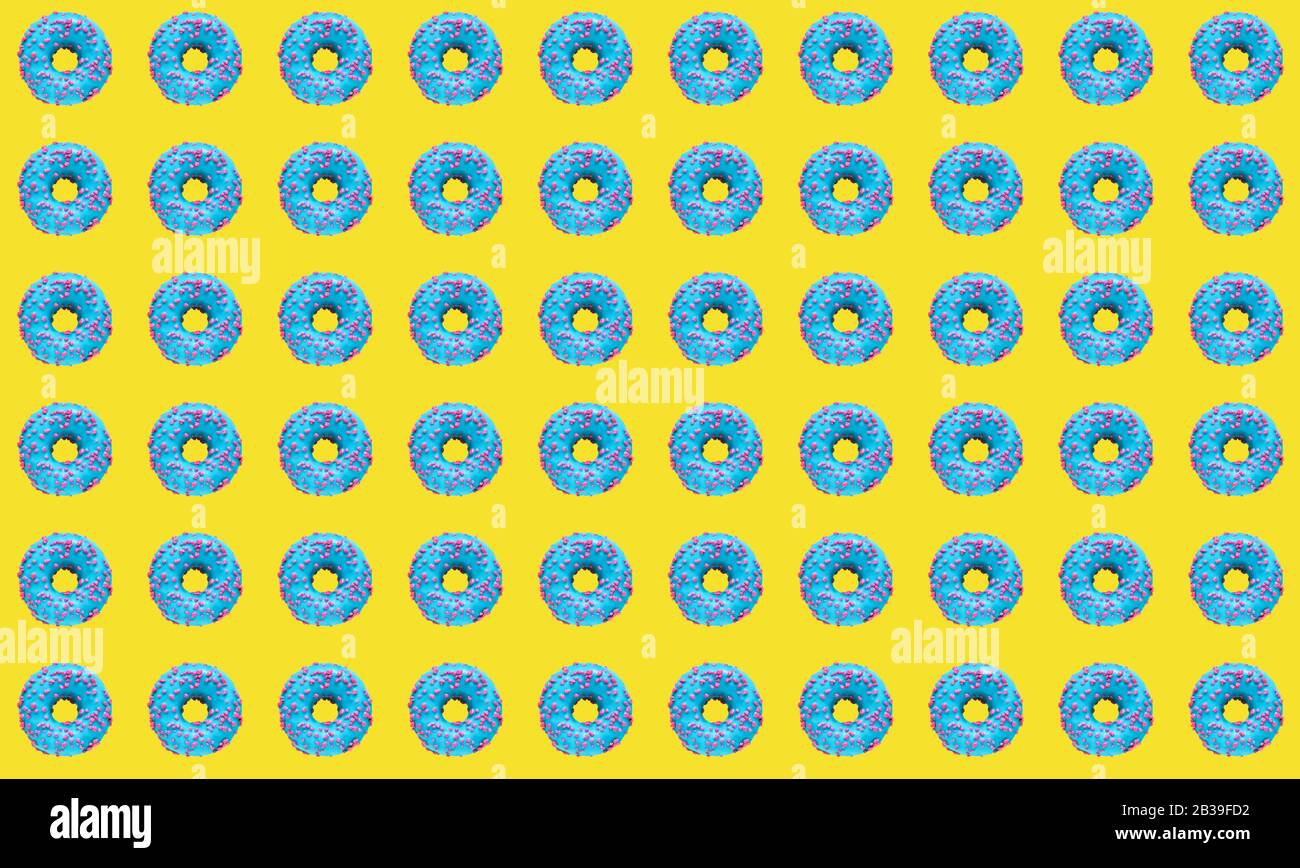 Pattern of a blue donuts on a yellow background. Flat lay Stock Photo