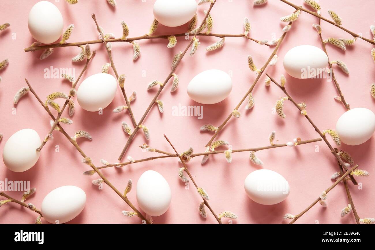 White eggs and willow branches on pink background Stock Photo