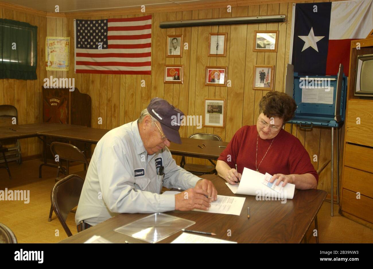 George West, Texas USA, March 9, 2004: Voting in a fire hall in this south Texas  Live Oak County community with paper ballots. Couple voting is water well driller Ed Pawlik and wife Patsy. © Bob Daemmrich Stock Photo