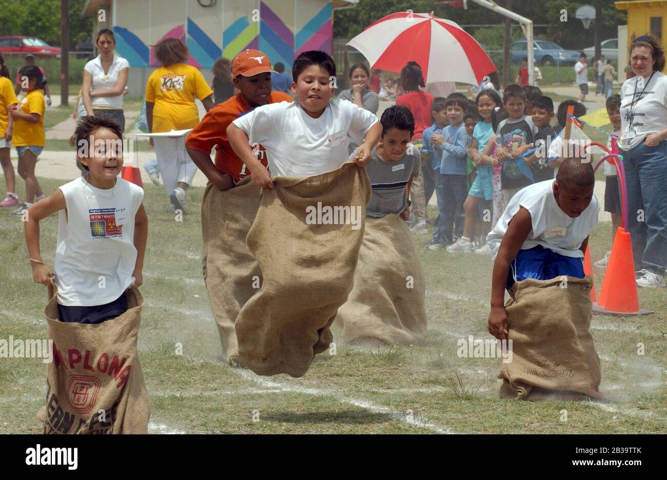 Austin Texas USA, circa 2004: Elementary school students compete in a sack race during the annual field day at Walnut Creek Elementary School. ©Bob Daemmrich Stock Photo
