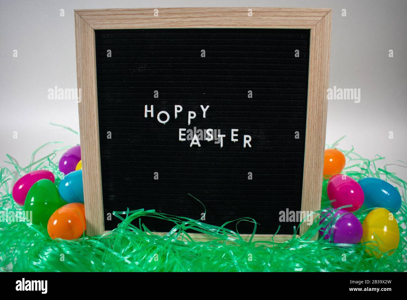 A Black Happy Easter Sign With White Letters Easter Grass and Easter