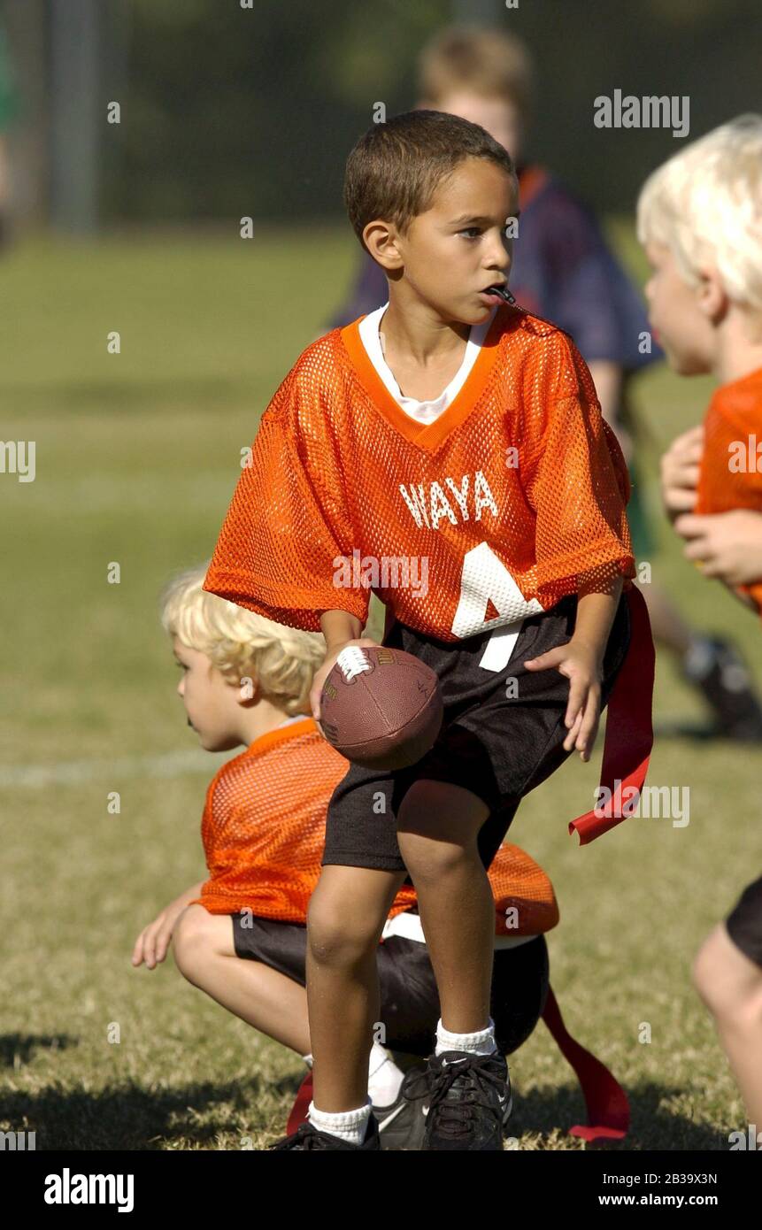 Austin, Texas USA, October 2004: Boys wearing plastic mouth guards run downfield during a youth league flag football game for 7-8-year-olds. ©Bob Daemmrich Stock Photo