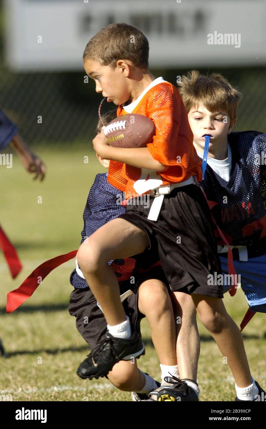 Austin, Texas USA, October 2004: Boys wearing plastic mouth guards run downfield during a youth league flag football game for 7-8-year-olds. ©Bob Daemmrich Stock Photo