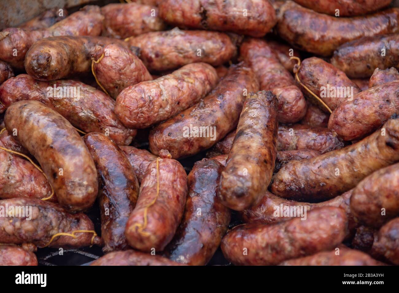 A grill full of coocked chorizos or sausages ready to eat a choripan Stock Photo