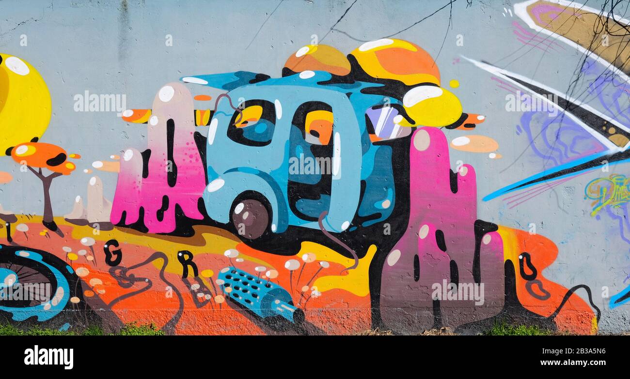 Modern graffiti in southern suburbs of Milan city, Italy, depicting a caravan with flowers and trees Stock Photo