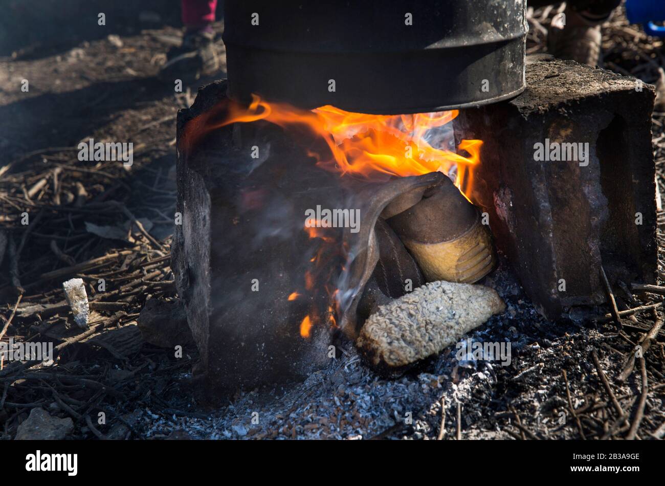 March 2, 2020, Saadnayel, Bekaa Valley, Lebanon: Old shoes are burn to heat  water to wash with outside of Mohamad Shehab Camp, an informal Syrian  refugee settlement located in the Bekaa Valley,