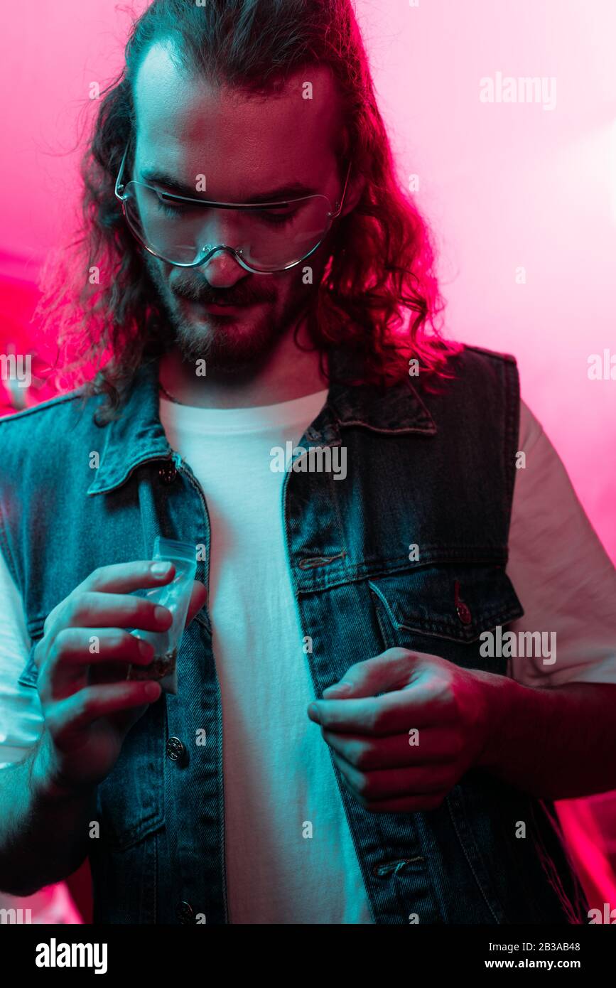 man holding plastic zipper bag with marijuana in nightclub Stock Photo
