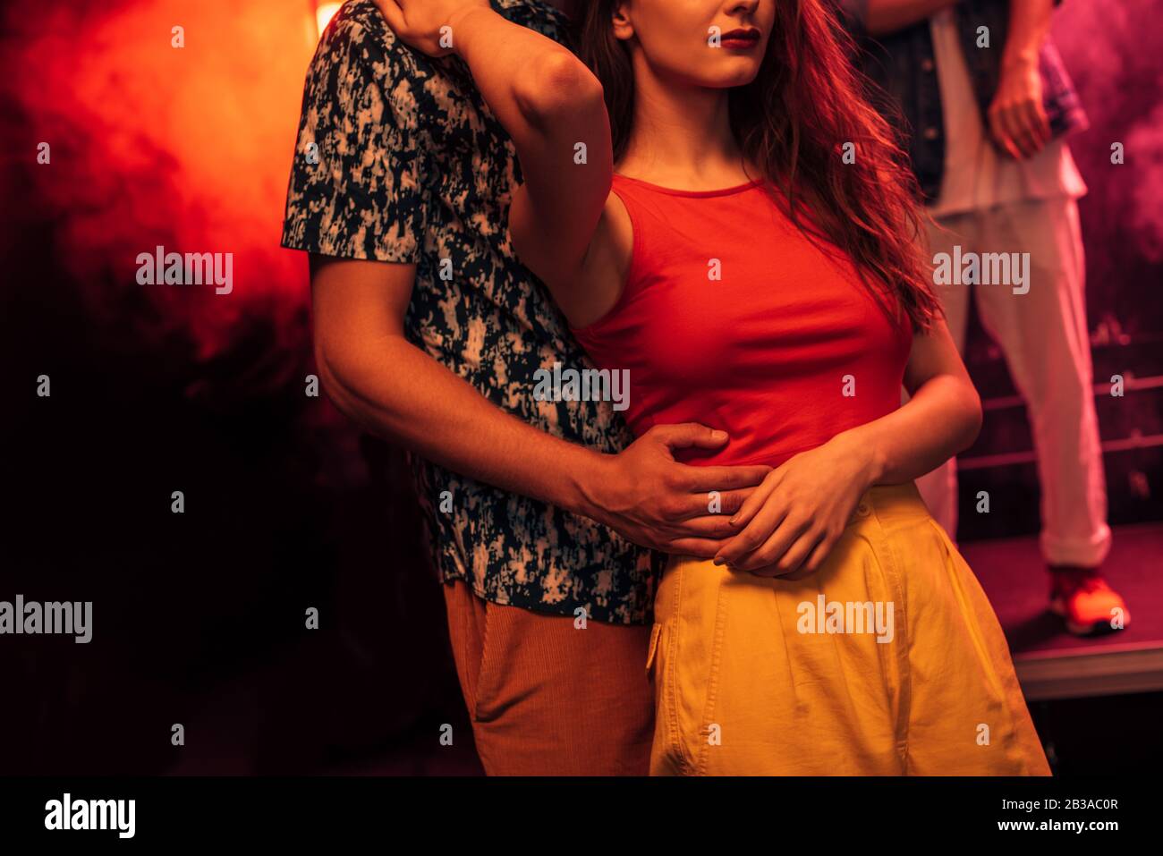 cropped view of man hugging girl during rave party in nightclub Stock ...