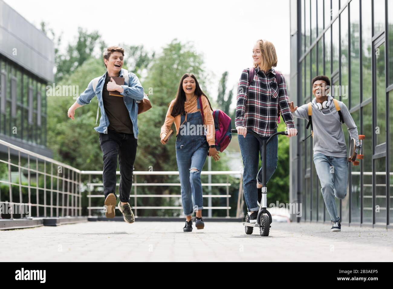 Students Running Riding happy and positive teenagers smiling, running and riding scooter Stock ...