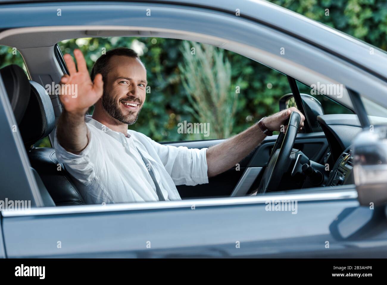 https://c8.alamy.com/comp/2B3AHP8/selective-focus-of-happy-man-driving-car-and-waving-hand-2B3AHP8.jpg