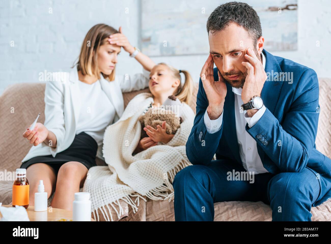 worried father touching head and mother sitting near diseased daughter ...
