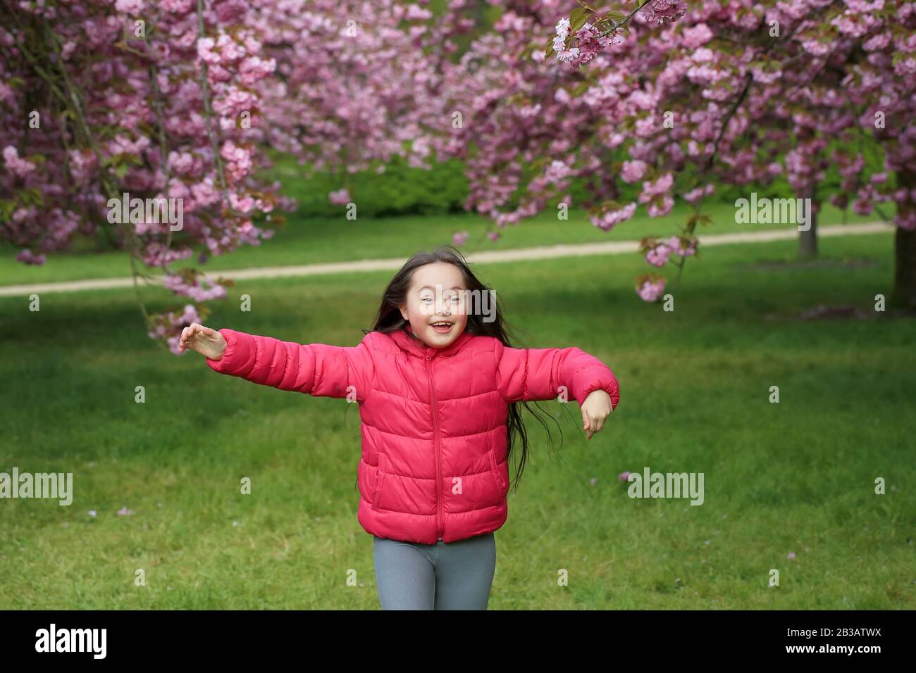 Happy beautiful girl in blossom park Stock Photo - Alamy