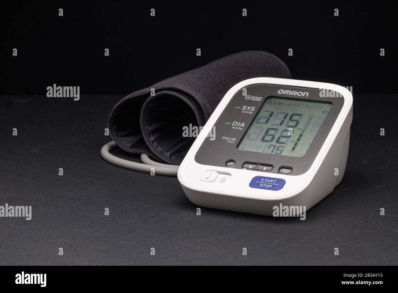 Home blood pressure monitor with arm cuff on dark background Known as a