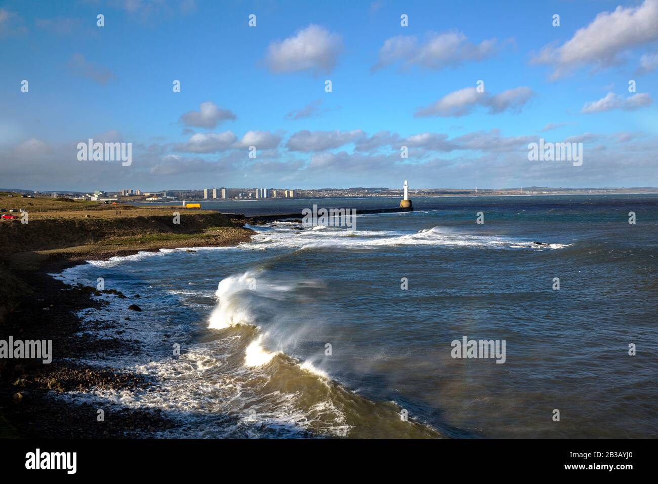 Several photos of Aberdeen South Breakwater, Girdleness Lighthouse, Greyhope Bay, and Aberdeen Harbour, big waves breaking, and vessel exiting port. Stock Photo