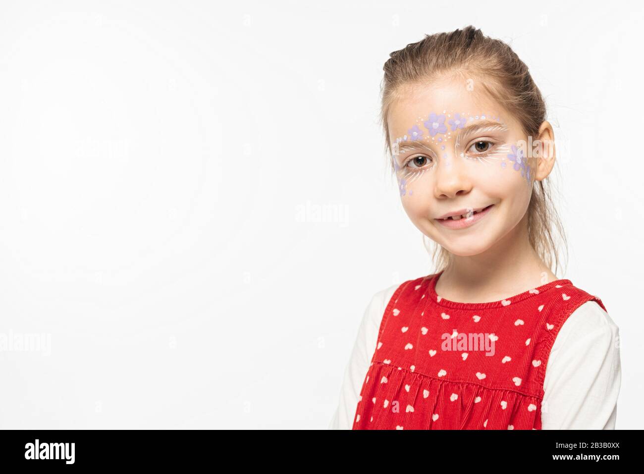 smiling child with floral painting on face looking at camera isolated on white Stock Photo