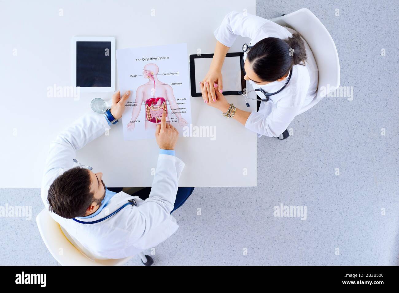 Medical team of doctors sitting and discussing in hospital at table ...