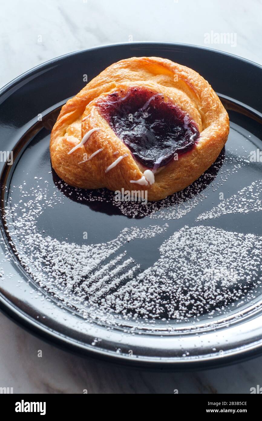 Blueberry glazed danish dessert pastry with icing and powdered sugar