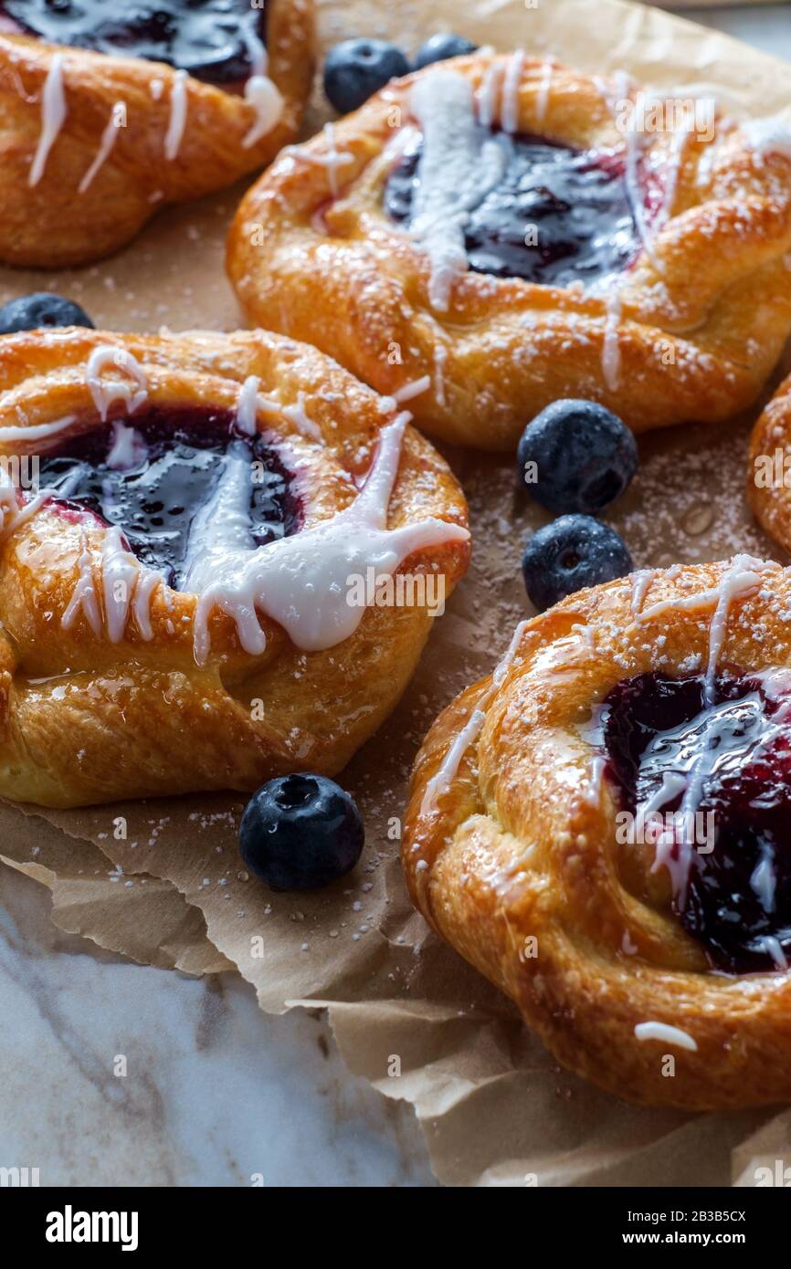 Blueberry glazed danish dessert pastries with icing and powdered sugar
