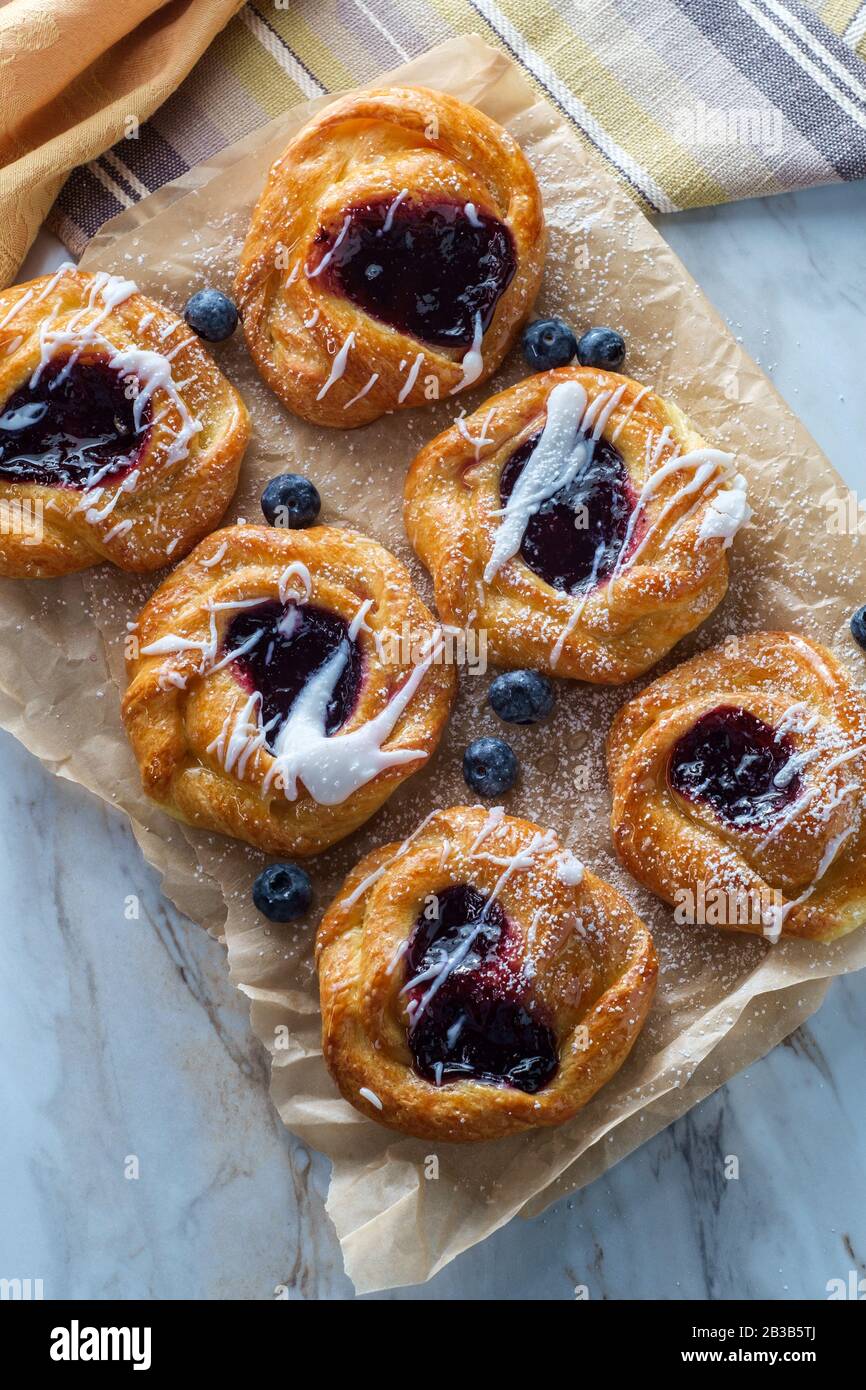 Blueberry glazed danish dessert pastries with icing and powdered sugar