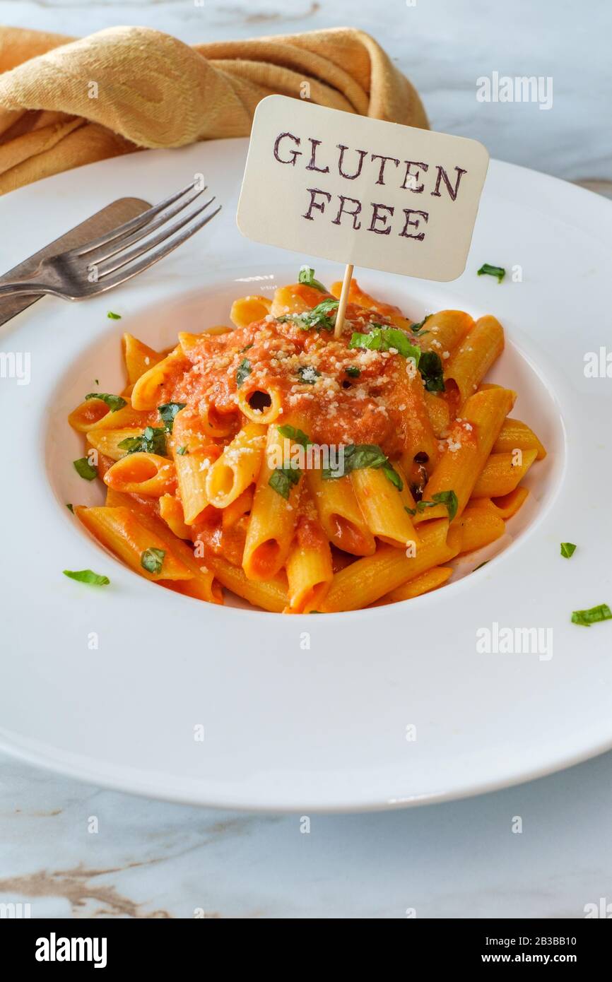 Glutenfree penne pasta in creamy vodka tomato sauce to be eaten by