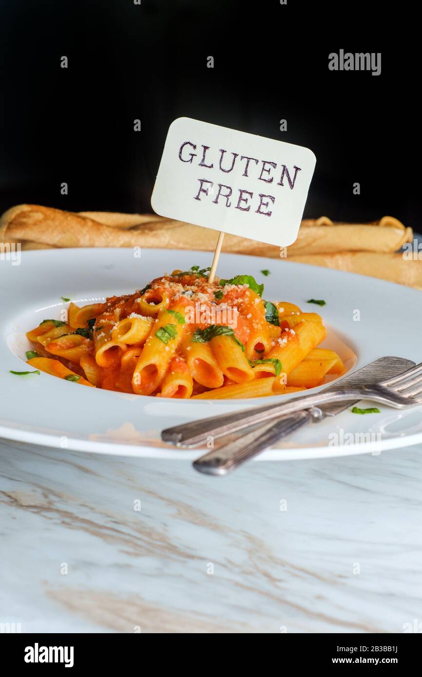 Glutenfree penne pasta in creamy vodka tomato sauce to be eaten by