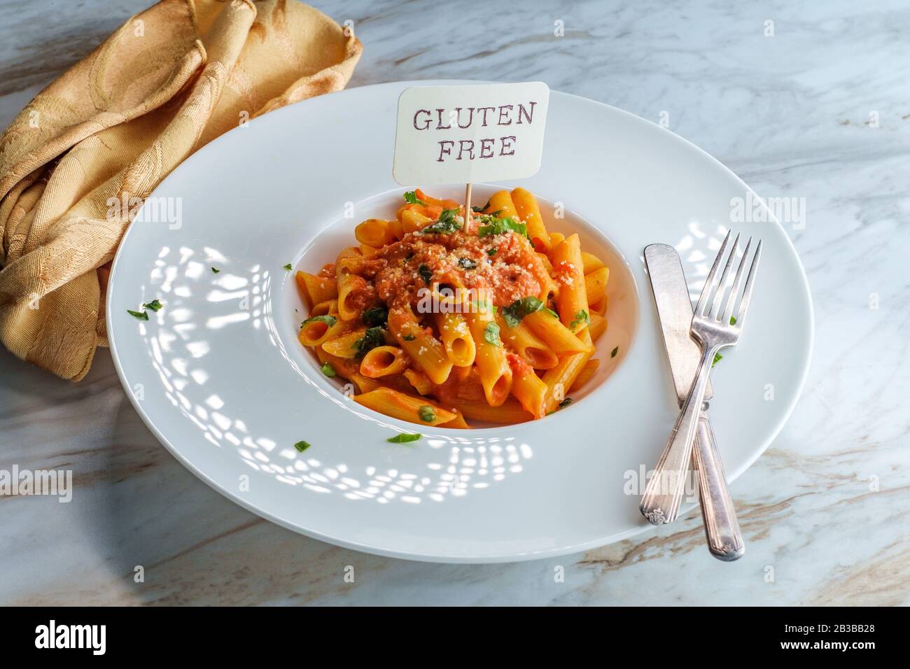Glutenfree penne pasta in creamy vodka tomato sauce to be eaten by