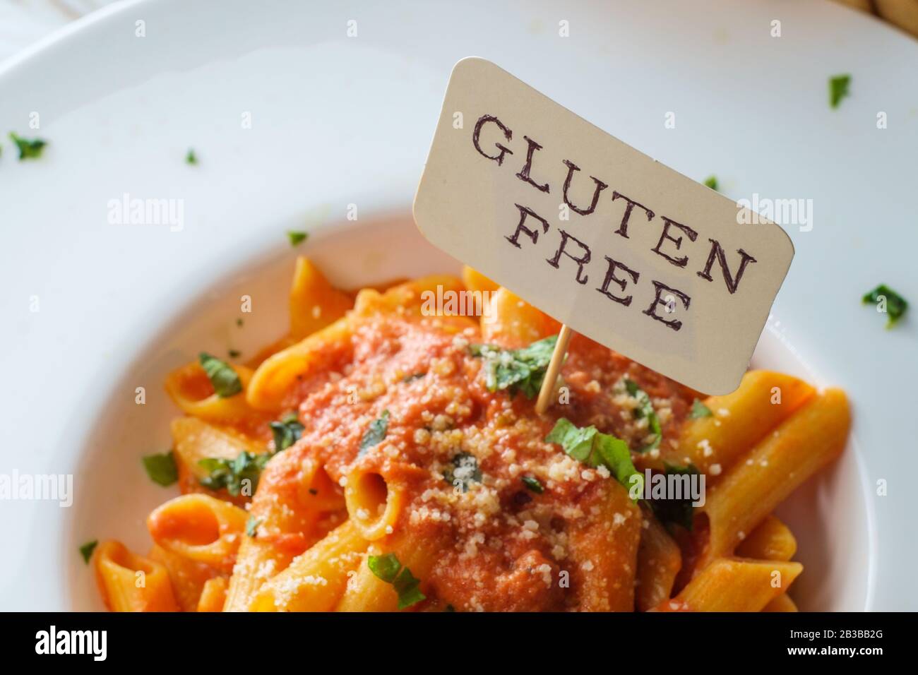 Glutenfree penne pasta in creamy vodka tomato sauce to be eaten by