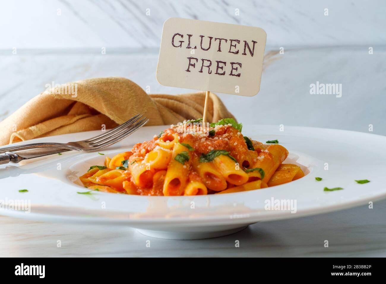 Glutenfree penne pasta in creamy vodka tomato sauce to be eaten by