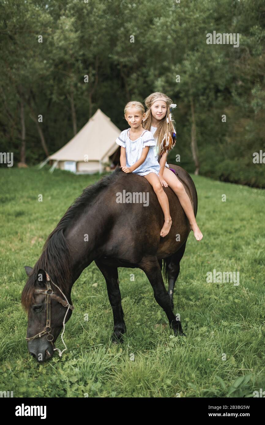 Two pretty little blond girls with long hair in casual wear and