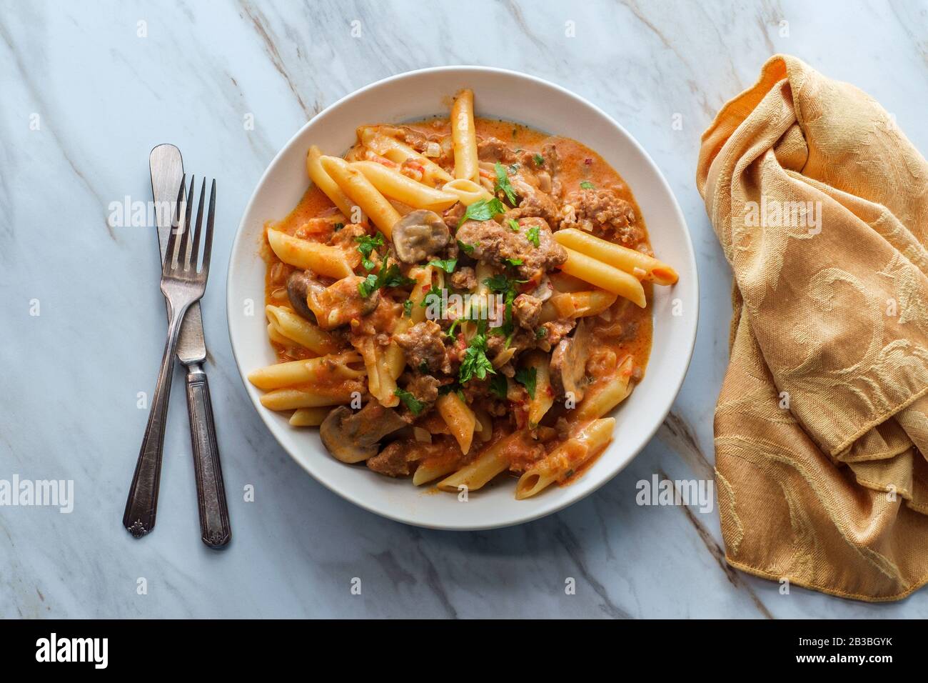 Italian penne pasta in creamy vodka tomato sauce with crumbled sausage