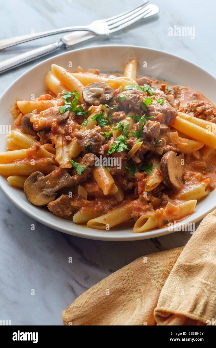 Italian penne pasta in creamy vodka tomato sauce with crumbled sausage