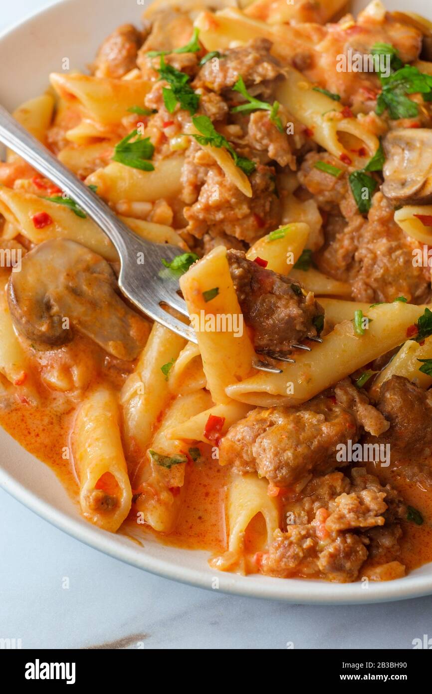 Italian penne pasta in creamy vodka tomato sauce with crumbled sausage