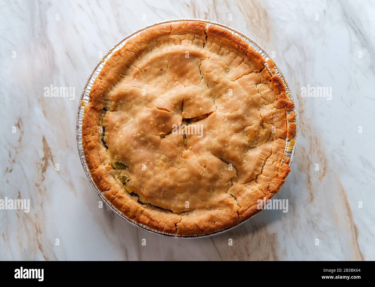Crispy flaky baked homemade chicken pot pie in tin foil pan Stock Photo