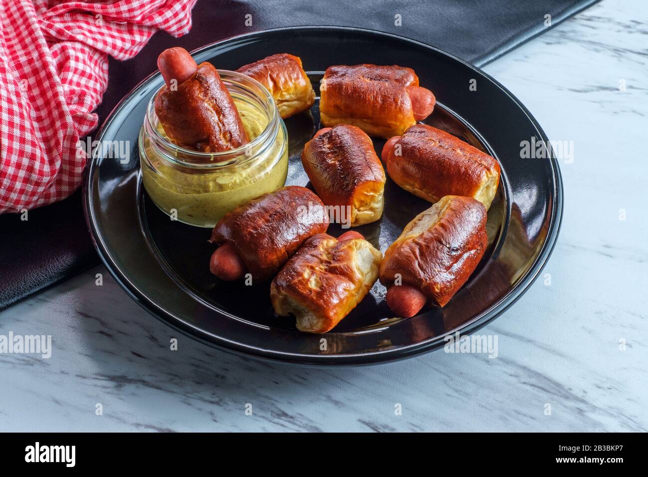 Mini pretzel hot dog pigs in a blanket with dijon mustard for dipping