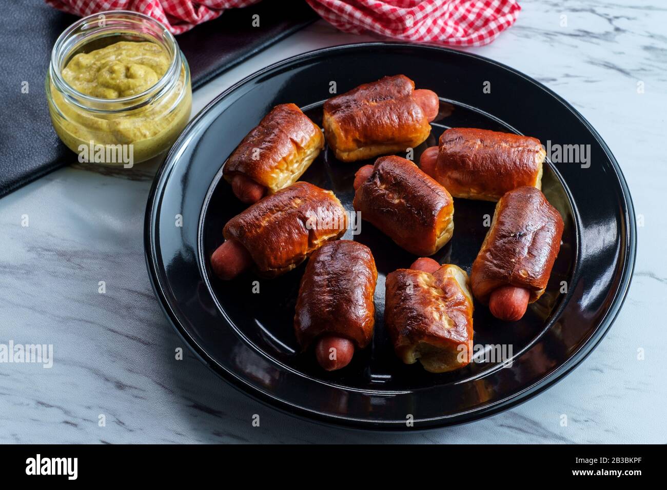 Mini pretzel hot dog pigs in a blanket with dijon mustard for dipping