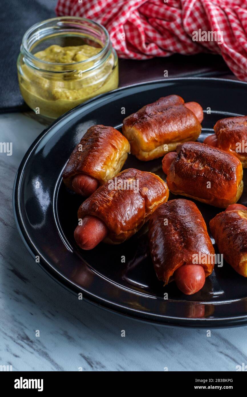 Mini pretzel hot dog pigs in a blanket with dijon mustard for dipping