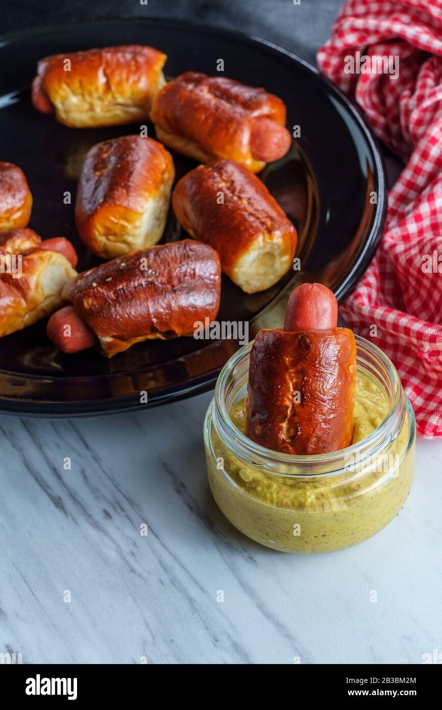 Mini pretzel hot dog pigs in a blanket with dijon mustard for dipping
