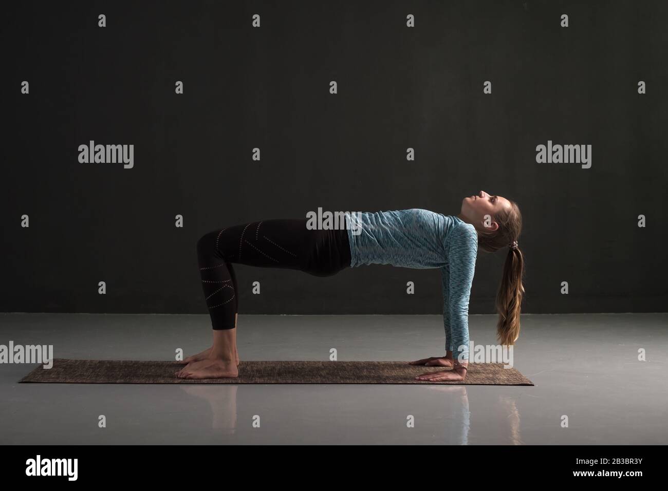 Woman practices yoga asana purvottanasana or upward facing plank full pose isolated on black background Stock Photo