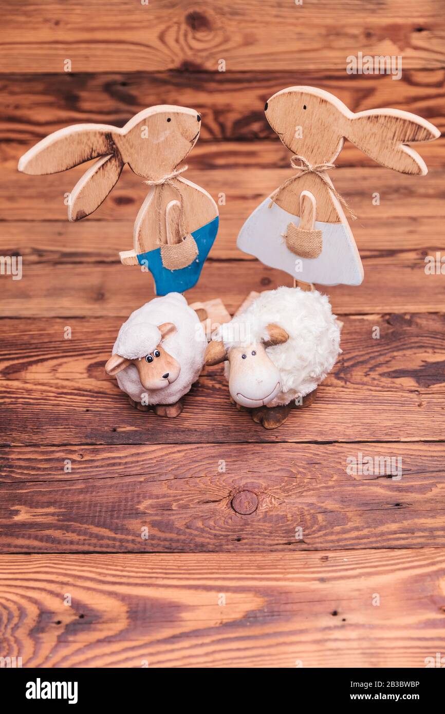 wooden easter bunnies and toy sheep all together on old wood background Stock Photo