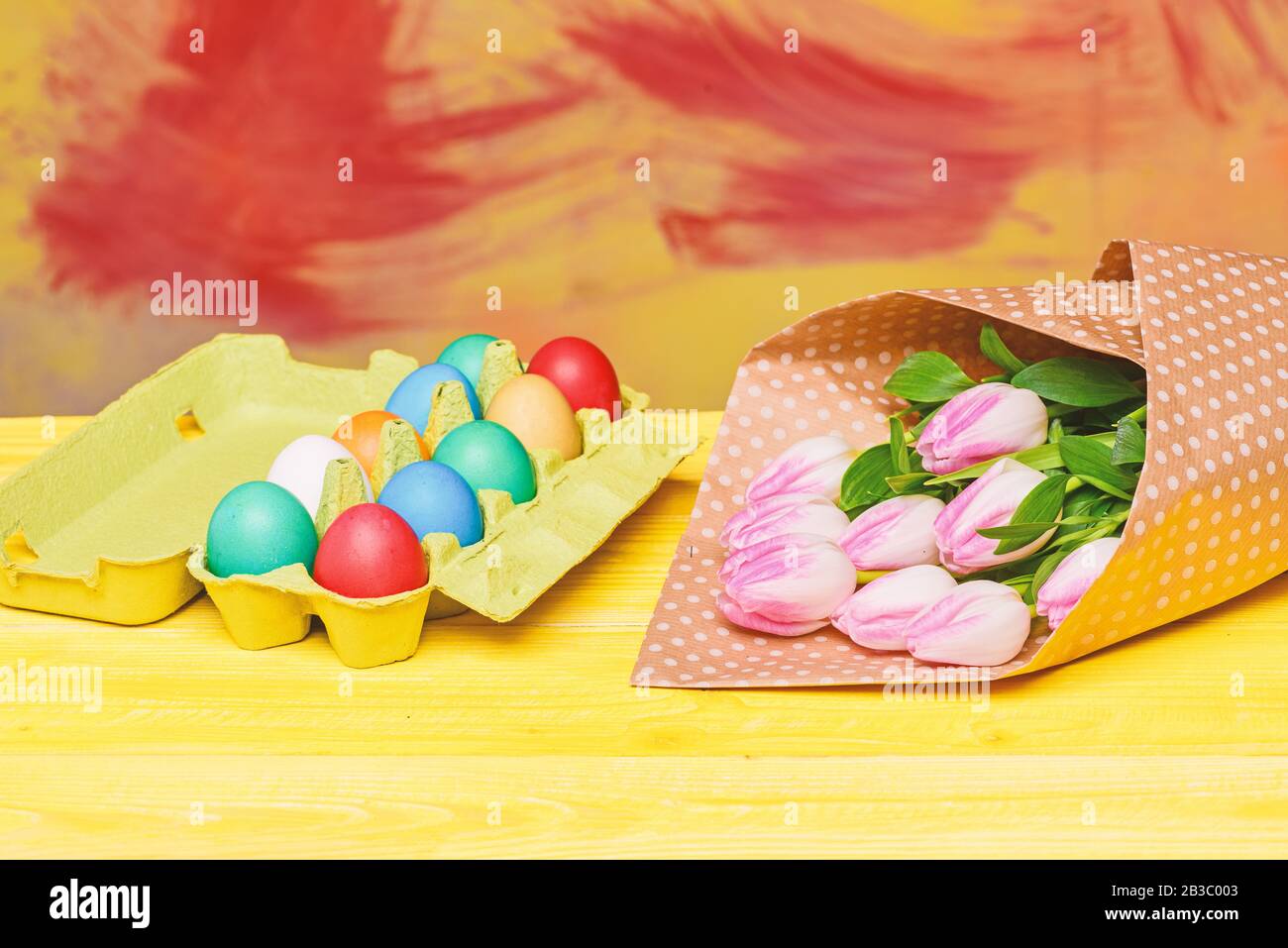 Egg hunt. painted eggs in egg tray. Spring holiday. Holiday celebration, preparation. Tulip flower bouquet. Healthy and happy holiday. Happy easter. Easter time. Stock Photo