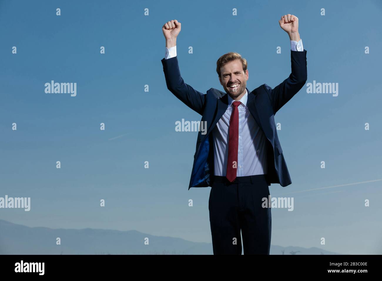 Cheerful businessman celebrating with his fist in the air while wearing ...