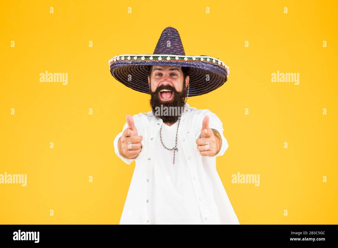 Fest and holiday. Celebrate traditions. hipster looks festive in sombrero. celebrating fiesta. happy man wear poncho. having fun on mexican party. sombrero party man. man in mexican sombrero hat. Stock Photo