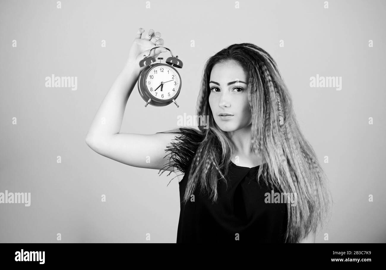 Pretty girl managing her time. Woman hold vintage alarm clock. Watch