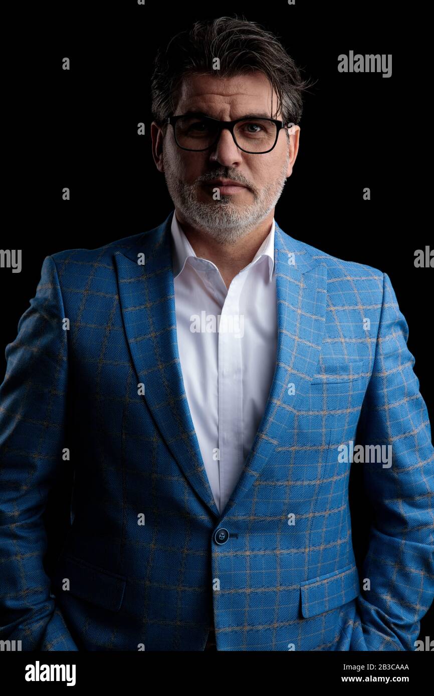 young formal business man wearing blue suit and glasses standing with ...