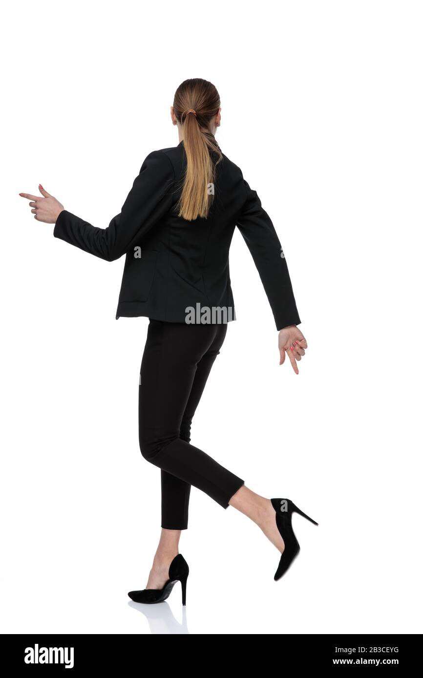 rear view of a businesswoman wearing black suit and posing in a relaxed ...
