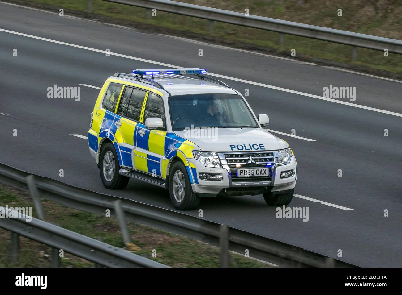 Police car emergency services vehicles driving on the M6 motorway near Preston in Lancashire, UK