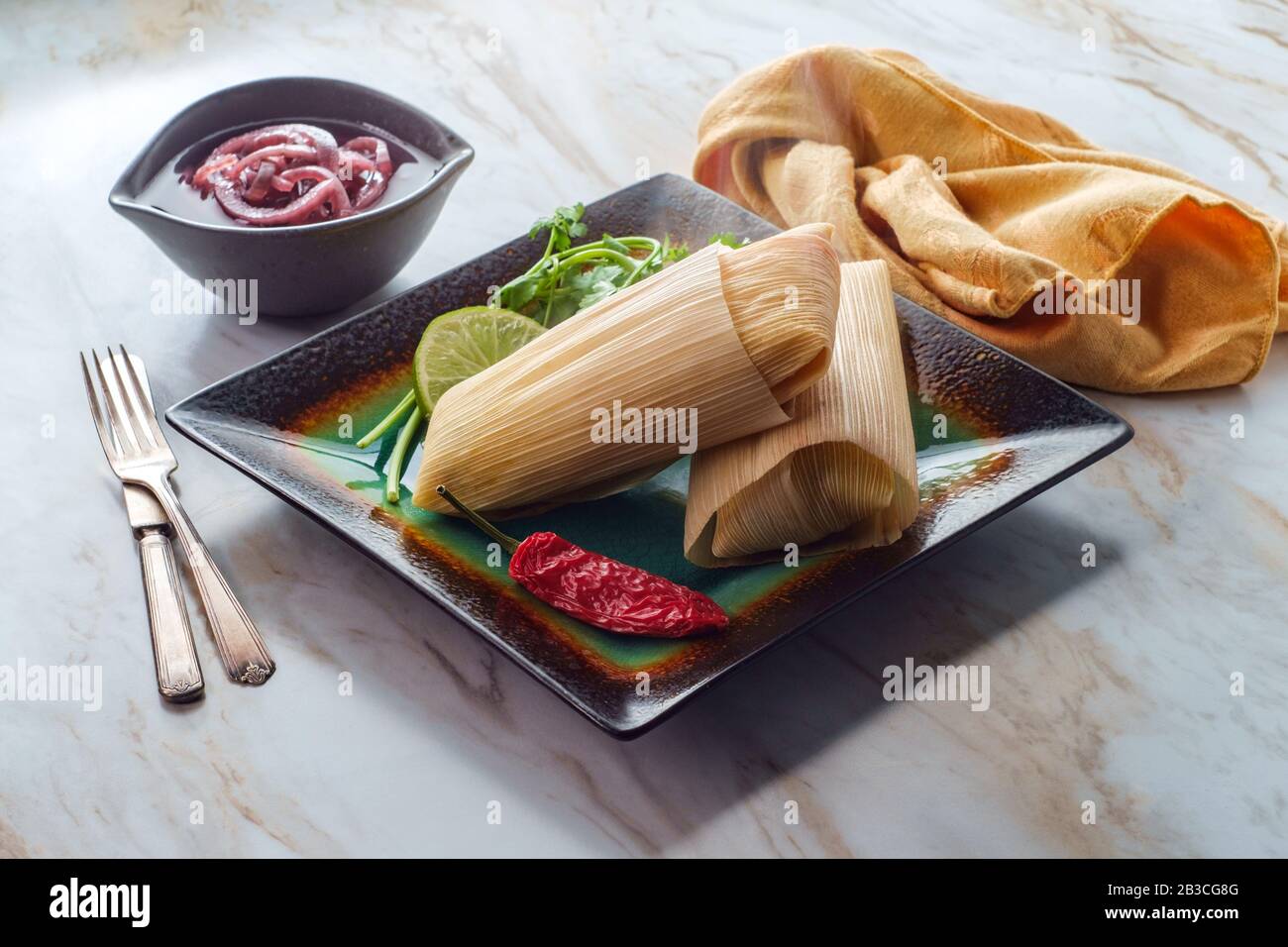 Mexican steamed chili and cheese masa tamales wrapped in corn husk
